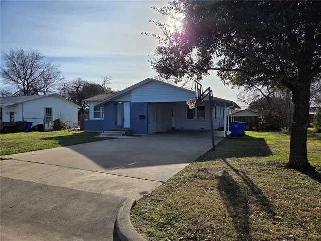 a front view of a house with a yard and trees