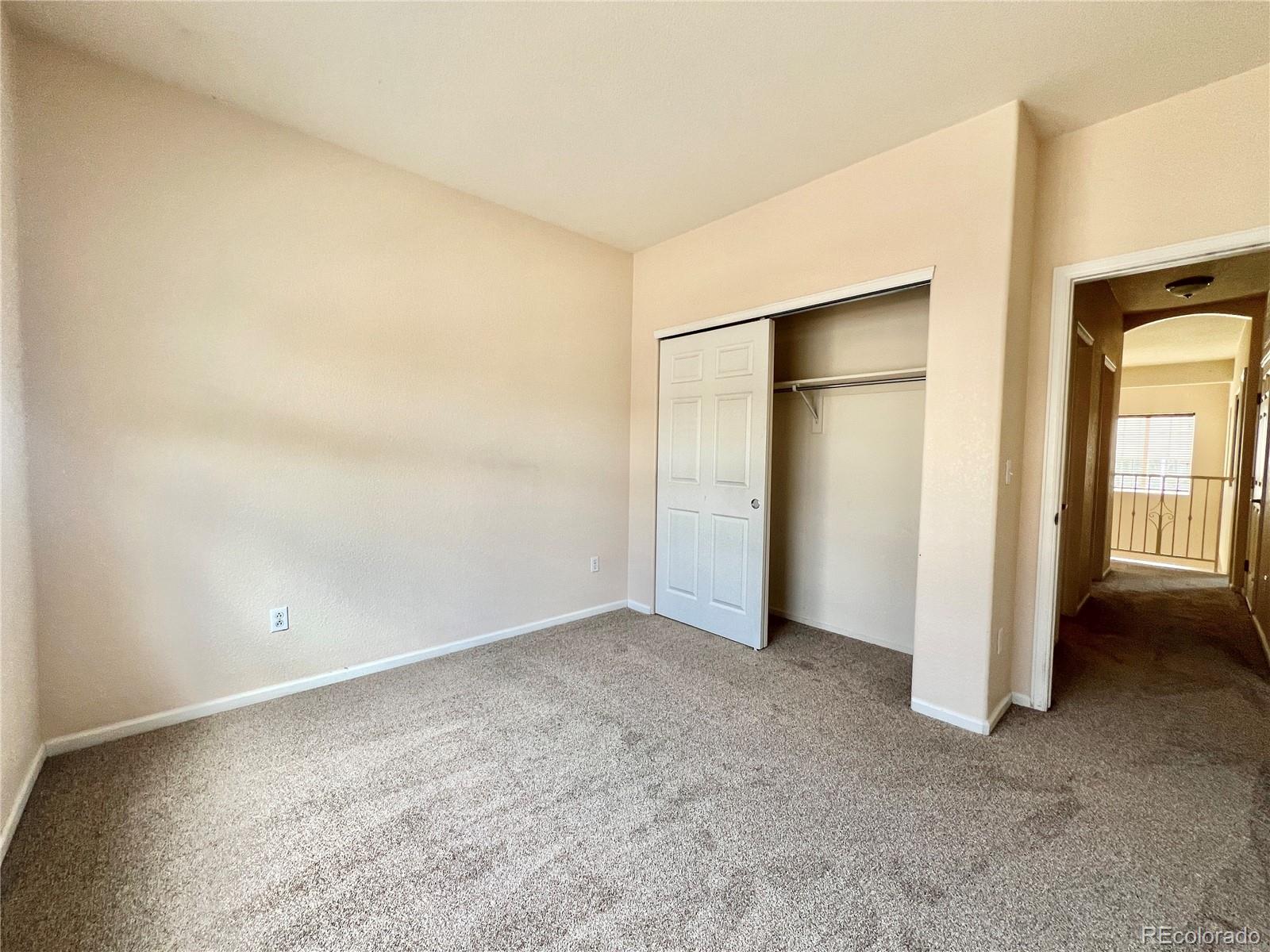 1385 South Chambers Road, Unit 102 Aurora, CO 80017 - Photo 17 of 20 an empty room with closet and windows