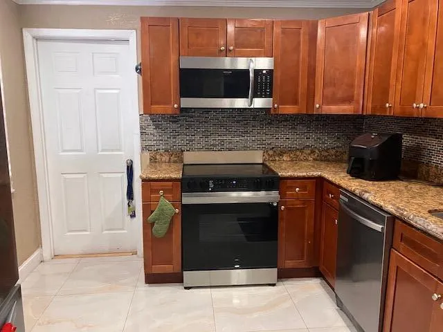 a kitchen with granite countertop stainless steel appliances and cabinets