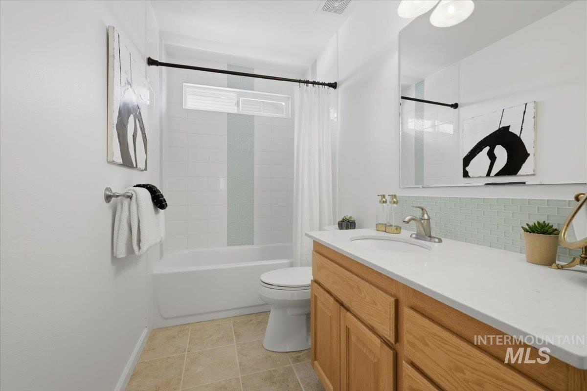 2075 North Springland Place Boise, ID 83713 - Photo 31 of 49 Bathroom featuring a vanity with light wood cabinetry, white countertop, and a tiled backsplash