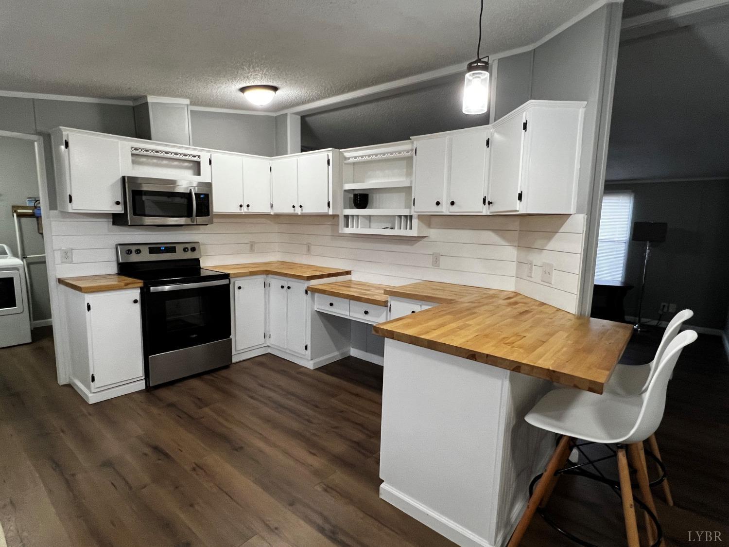 141 Paisley Road Gretna, VA 24557 - Photo 8 of 19 a kitchen with stainless steel appliances granite countertop a sink a stove top oven a counter space and cabinets