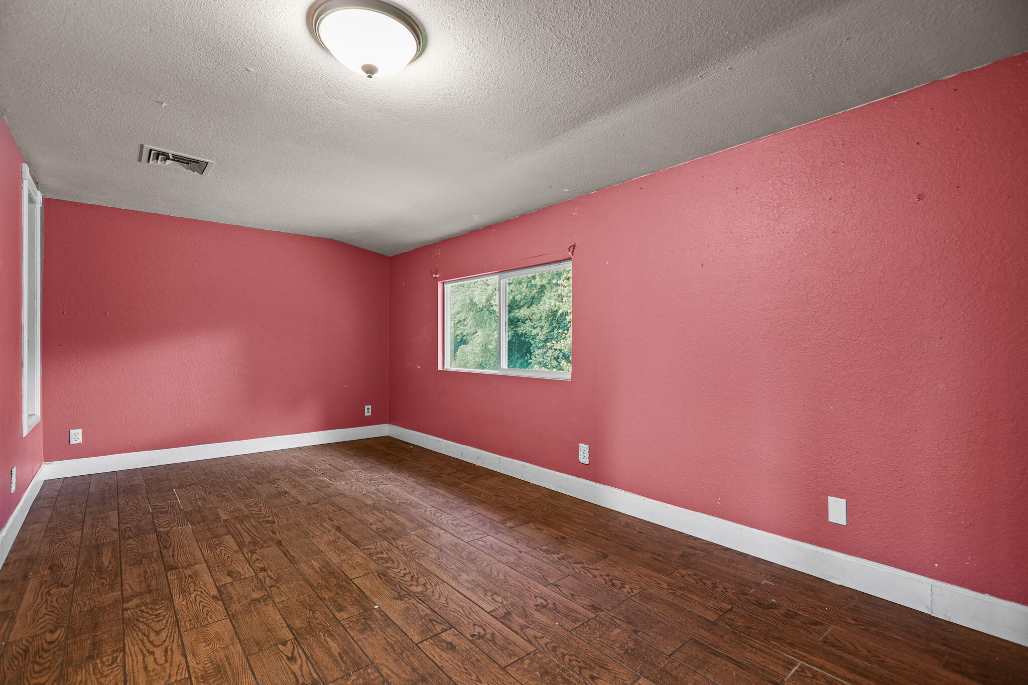 18855 Turnell Road Cottonwood, CA 96022 - Photo 11 of 34 an empty room with wooden floor and windows