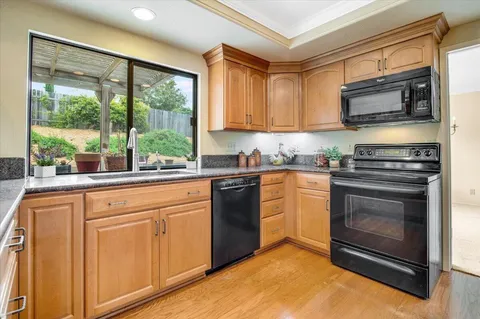 a kitchen with stainless steel appliances granite countertop a stove a sink and a refrigerator