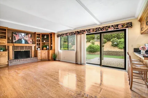 a view of an empty room with a fireplace and a window