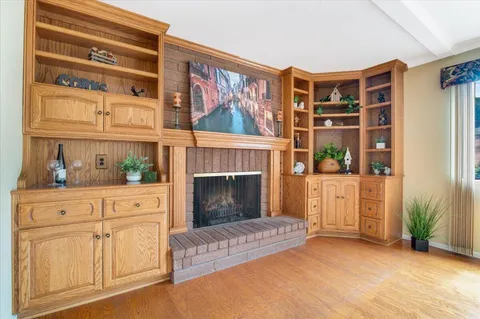 a view of an empty room with window and kitchen view