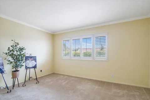a bedroom with a bed table chair and a window