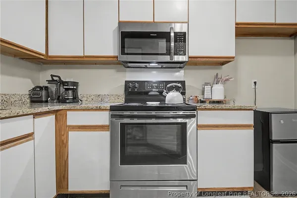 a kitchen with stainless steel appliances granite countertop a stove and a microwave