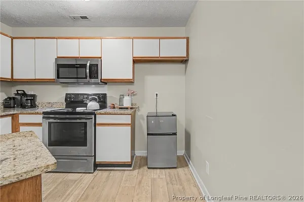 a kitchen with stainless steel appliances granite countertop a stove a sink and a microwave