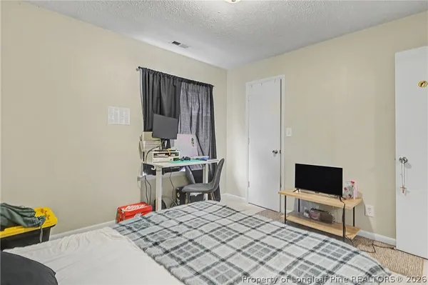 a bedroom with a bed and a flat screen tv