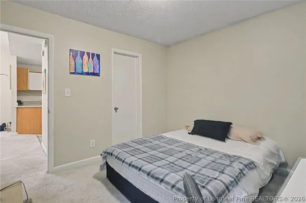 a bedroom with a bed and painting on the wall