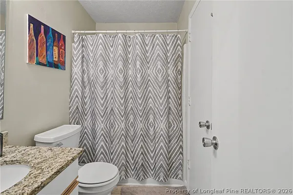 a white toilet sitting next to a shower curtain