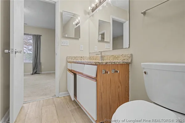 a bathroom with a granite countertop toilet sink and mirror
