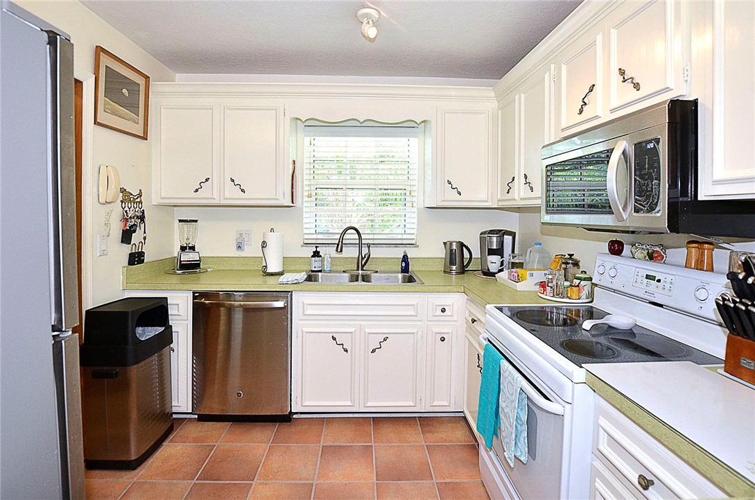 900 Jasmine Lane, Unit 9A Vero Beach, FL 32963 - Photo 11 of 26 a kitchen with stainless steel appliances granite countertop a sink stove refrigerator and cabinets