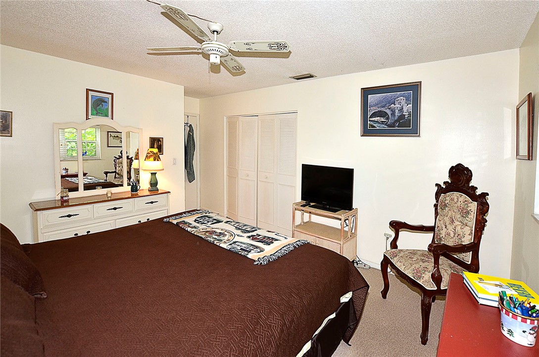 900 Jasmine Lane, Unit 9A Vero Beach, FL 32963 - Photo 14 of 26 a bedroom with a bed and a flat screen tv