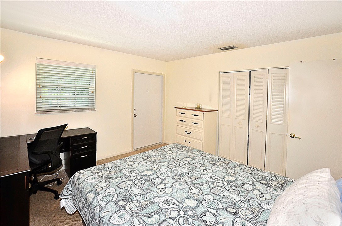 900 Jasmine Lane, Unit 9A Vero Beach, FL 32963 - Photo 17 of 26 a bedroom with a bed and a desk