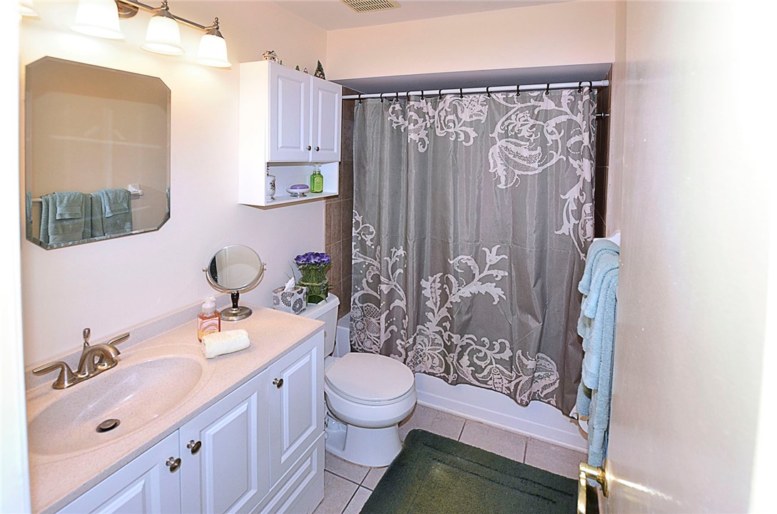 900 Jasmine Lane, Unit 9A Vero Beach, FL 32963 - Photo 18 of 26 a bathroom with a sink a toilet and shower curtain