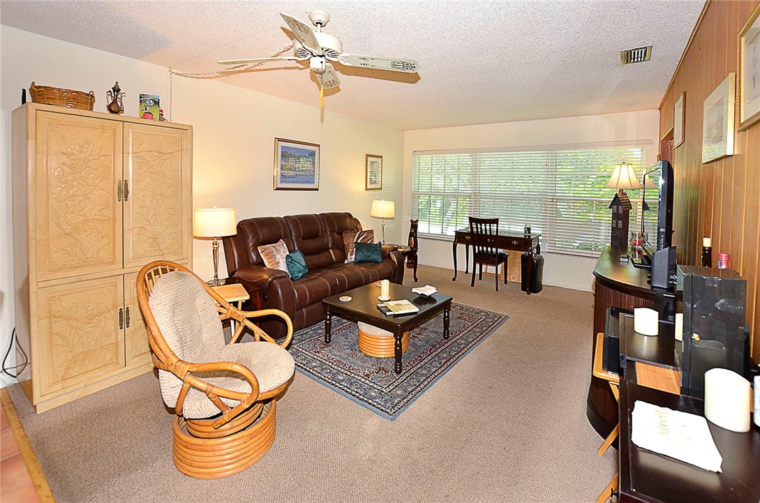 900 Jasmine Lane, Unit 9A Vero Beach, FL 32963 - Photo 8 of 26 a living room with furniture a flat screen tv and a large window