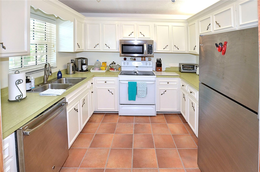 900 Jasmine Lane, Unit 9A Vero Beach, FL 32963 - Photo 10 of 26 a kitchen with a sink cabinets and a window