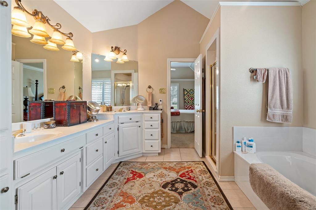 8913 Brierfield Road Granbury, TX 76049 - Photo 24 of 40 a spacious bathroom with a double vanity sink a mirror a bathtub and next to a window