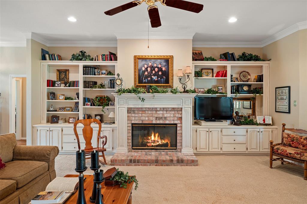 8913 Brierfield Road Granbury, TX 76049 - Photo 5 of 40 a living room with furniture a flat screen tv and a fireplace