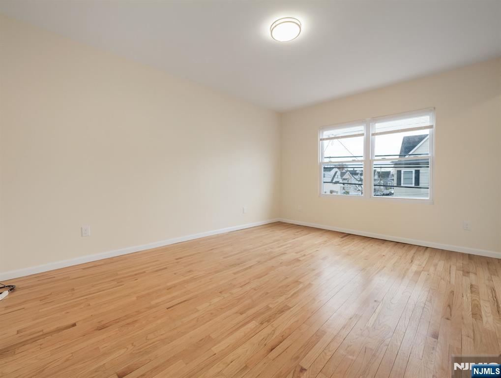 413 Lanza Avenue Garfield, NJ 07026 - Photo 12 of 37 an empty room with wooden floor and windows