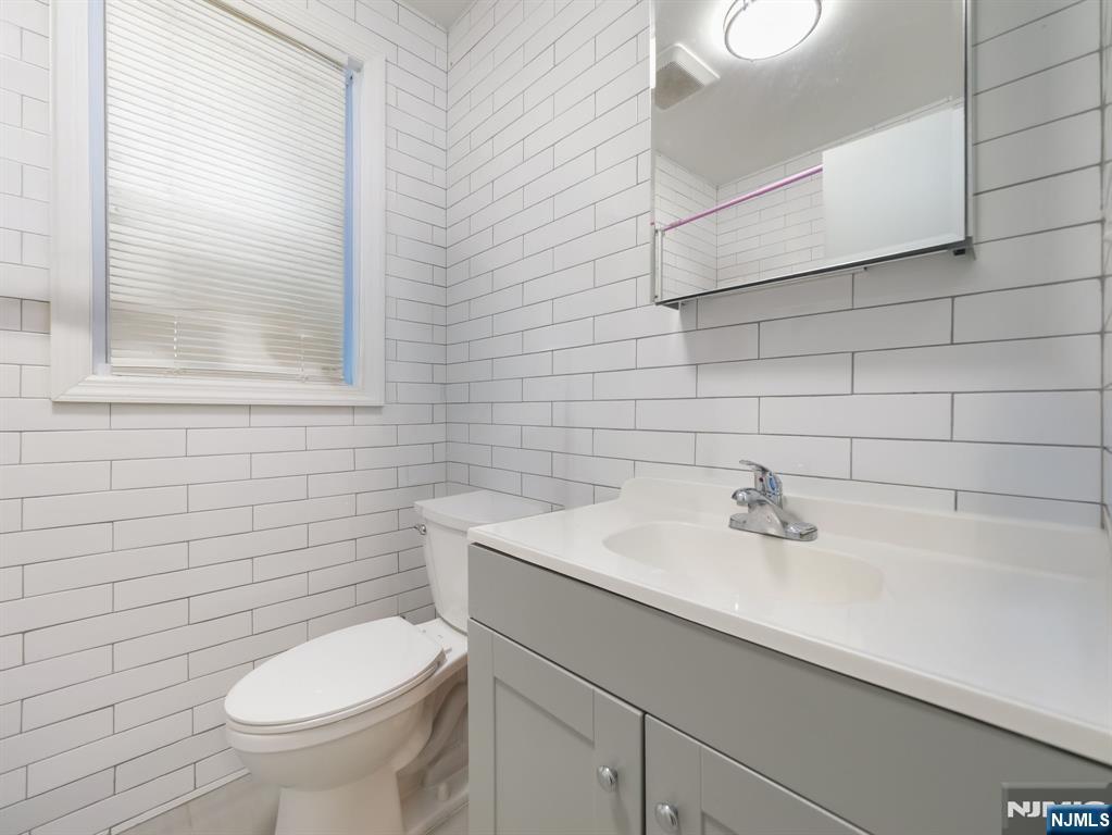 413 Lanza Avenue Garfield, NJ 07026 - Photo 22 of 37 a bathroom with a sink a toilet and mirror