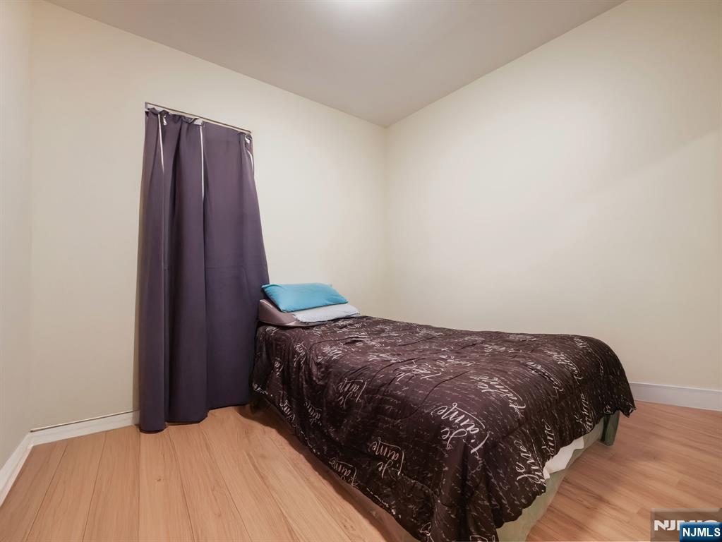 413 Lanza Avenue Garfield, NJ 07026 - Photo 24 of 37 a bedroom with a bed and wooden floor