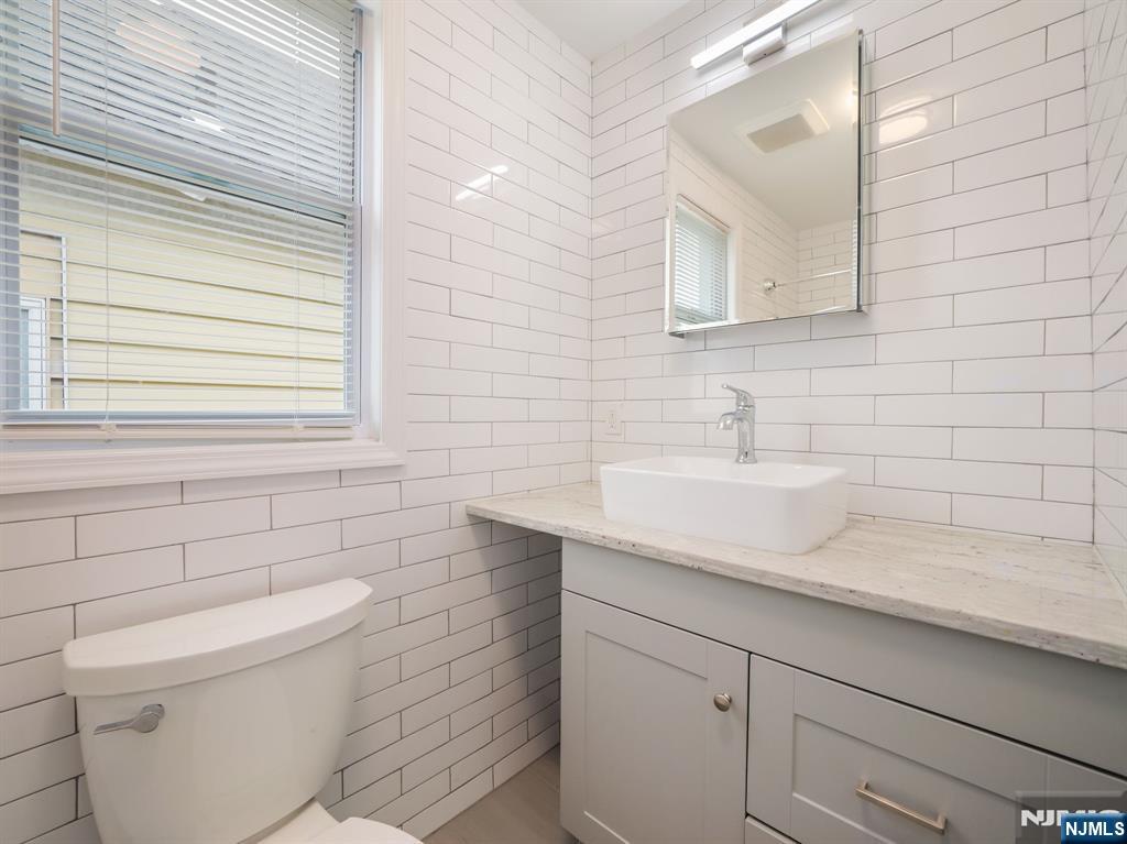 413 Lanza Avenue Garfield, NJ 07026 - Photo 9 of 37 a bathroom with a sink a toilet and mirror