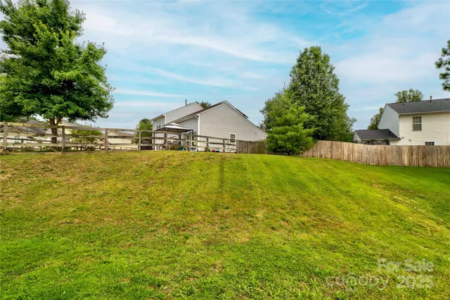 a view of a large pool with lawn chairs under an umbrella