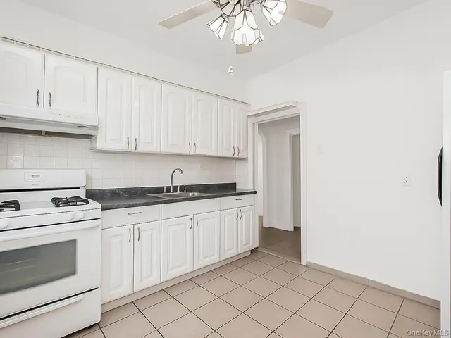 a kitchen with granite countertop white cabinets and white appliances