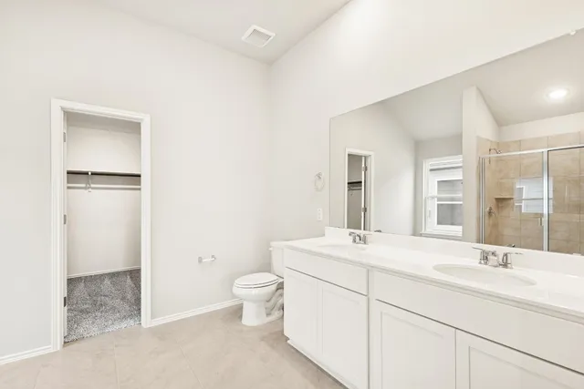 a bathroom with a toilet a sink a mirror and vanity