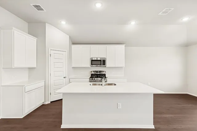 a kitchen with kitchen island a stove a sink and a refrigerator