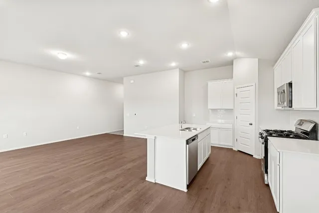 a kitchen with a stove a sink and a refrigerator