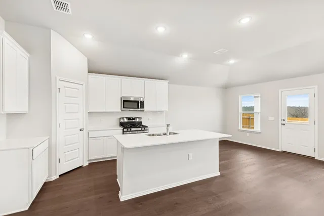 a kitchen with white cabinets and stainless steel appliances