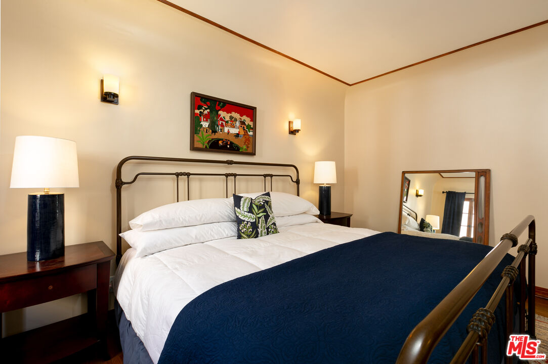 1169 Hi Point Street Los Angeles, CA 90035 - Photo 20 of 27 a bedroom with a bed and a lamp on table