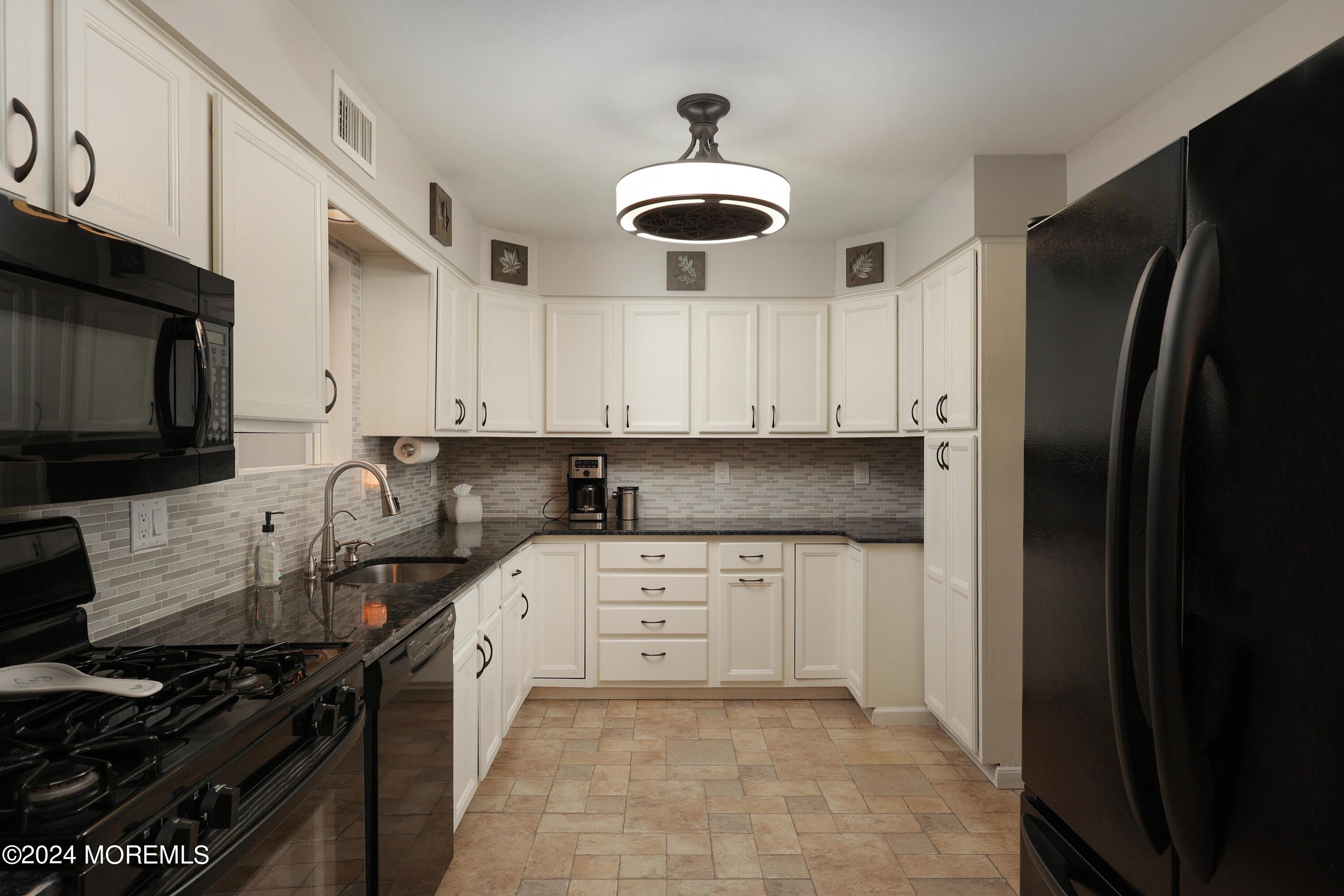 1058 Maxim Southard Road Howell, NJ 07731 - Photo 5 of 34 a kitchen with a refrigerator and a stove top oven