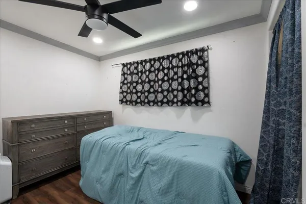 a spacious bedroom with a bed and a ceiling fan