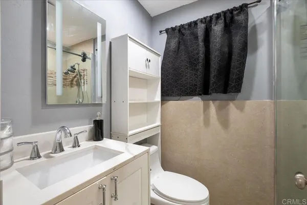 a bathroom with a sink a toilet and shower