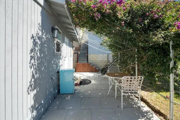 a view of a patio with table and chairs and floor to ceiling window