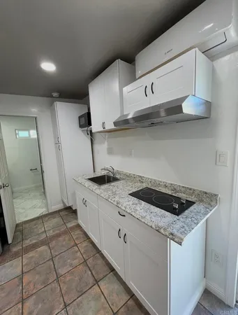 a kitchen that has a sink a stove and cabinets