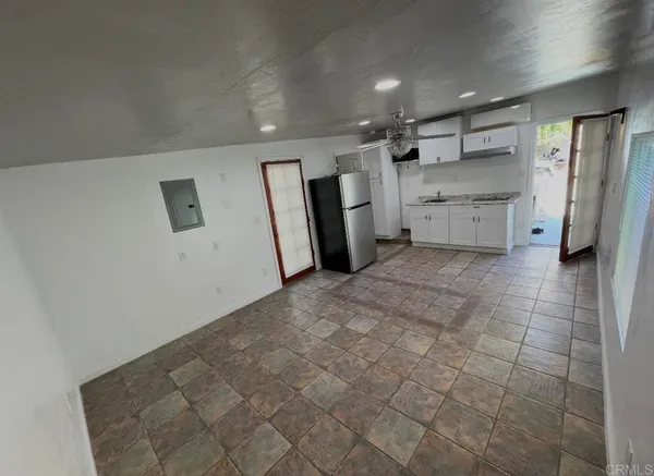 a view of a refrigerator in kitchen and a window