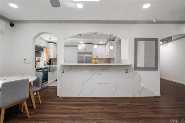 a view of a living room and kitchen with wooden floor