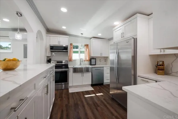 a kitchen with a sink stainless steel appliances and white cabinets