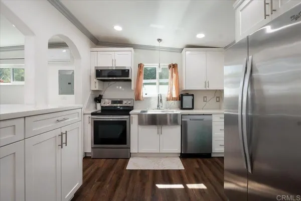 a kitchen with a refrigerator and a stove top oven