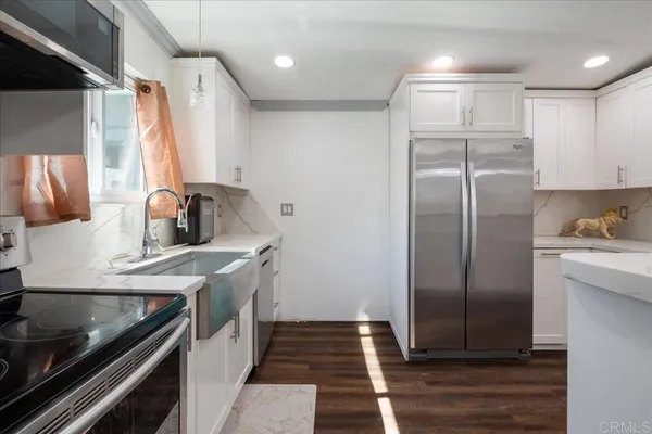 a kitchen with stainless steel appliances granite countertop a sink stove and refrigerator