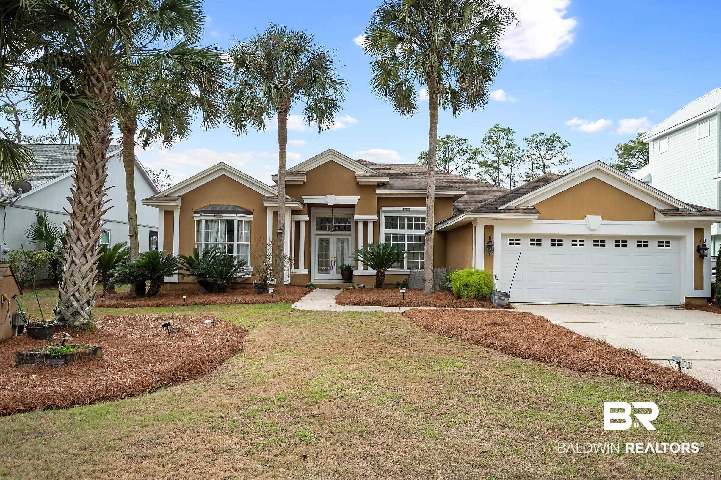 8591 Bay Harbor Road Elberta, AL 36530 - Photo 4 of 56 View of front of property with a front lawn, stucco siding, concrete driveway, french doors, and an attached garage