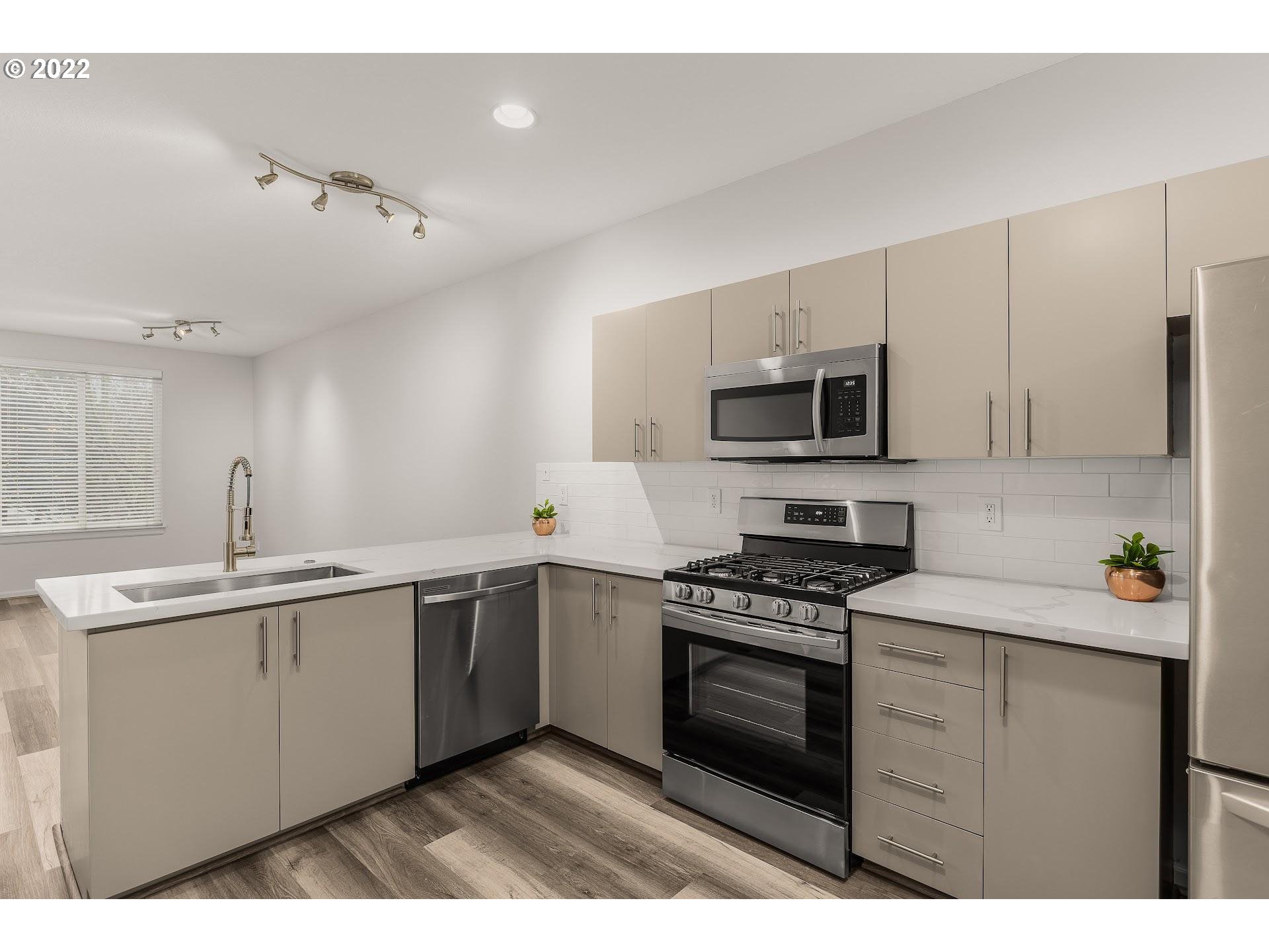 16695 Southwest Baseline Road Beaverton, OR 97006 - Photo 2 of 19 a kitchen with stainless steel appliances a sink stove and microwave