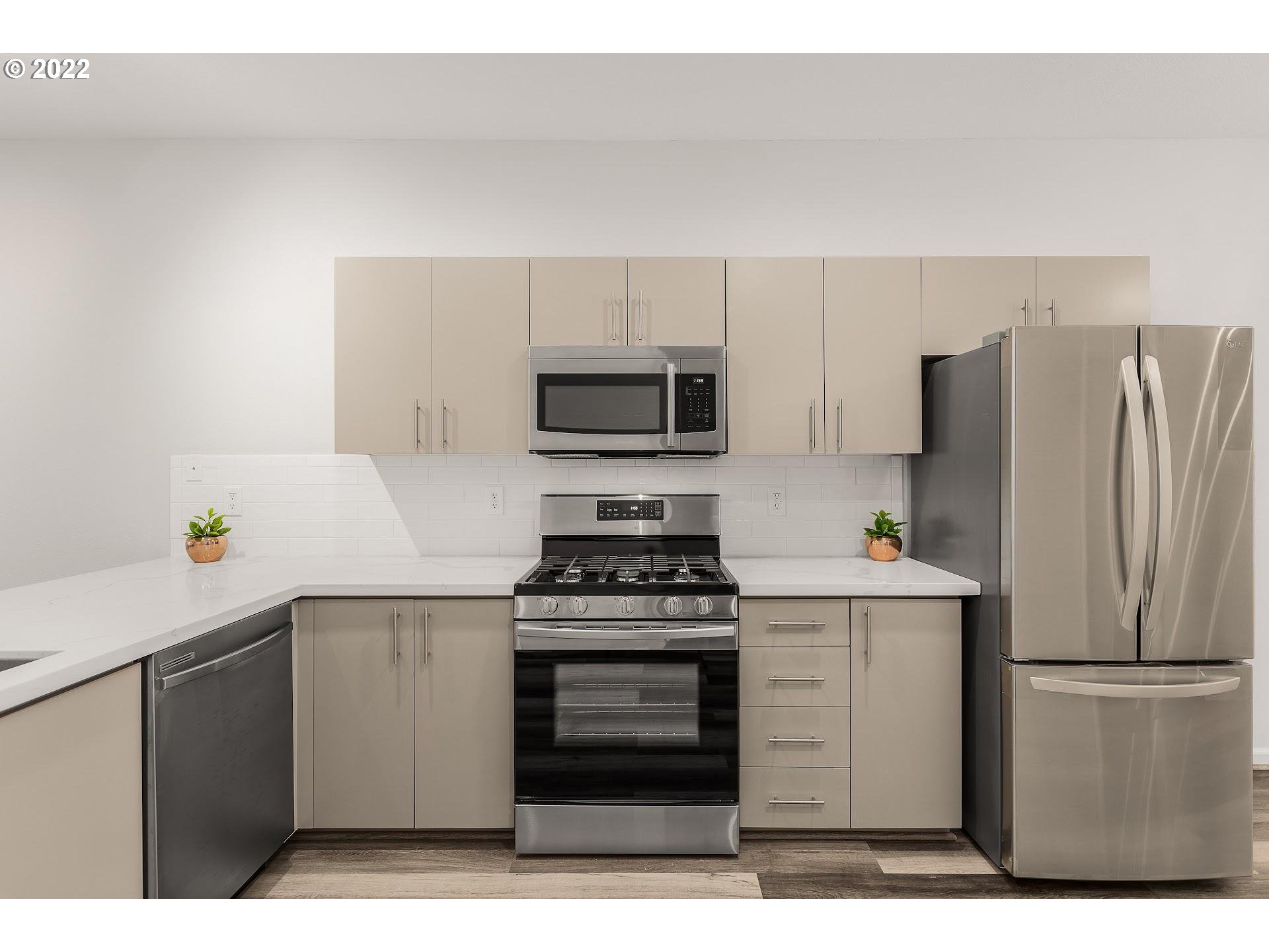 16695 Southwest Baseline Road Beaverton, OR 97006 - Photo 3 of 19 a kitchen with a stove a refrigerator and a microwave
