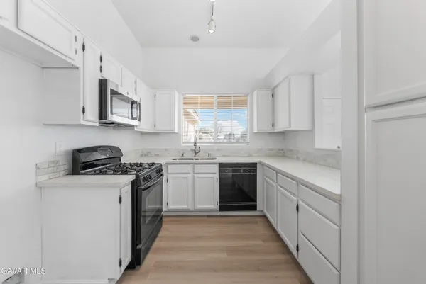 a kitchen with stainless steel appliances granite countertop a stove a sink dishwasher and a refrigerator