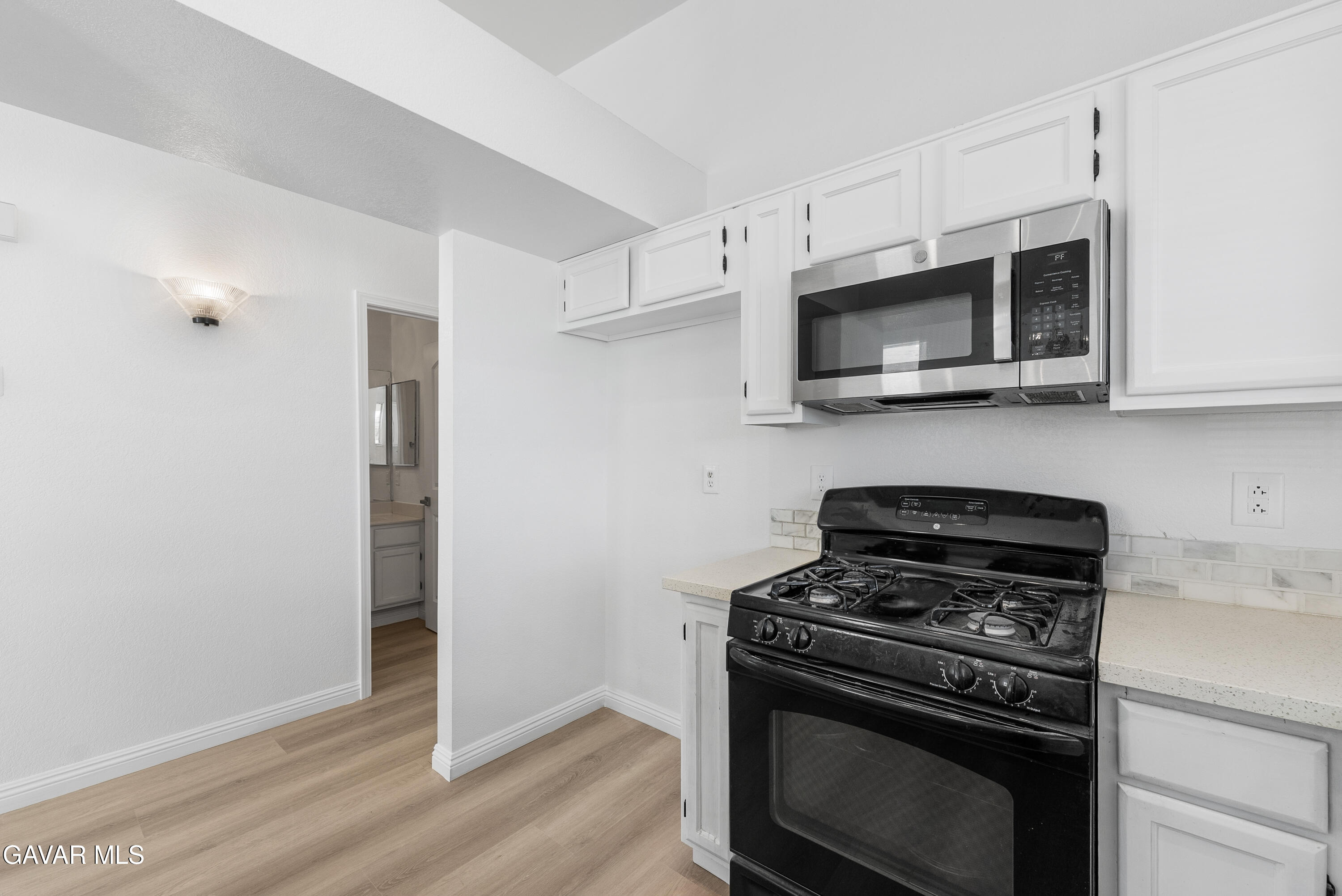 3209 Titcher Lane Rosamond, CA 93560 - Photo 11 of 36 a kitchen with stainless steel appliances a stove a microwave and cabinets